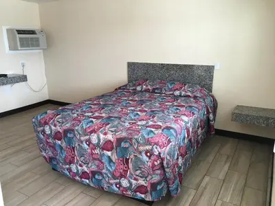 a bedroom with a bed with a colorful blanket at Ace Budget Motel in San Diego