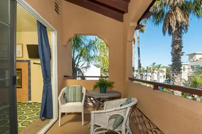 a balcony with a table and chairs and palm trees at Rooftop Deck Spectacular Ocean View M-A in Oceanside
