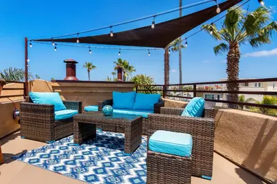 a patio with wicker chairs and a table at Rooftop Deck Spectacular Ocean View M-A in Oceanside