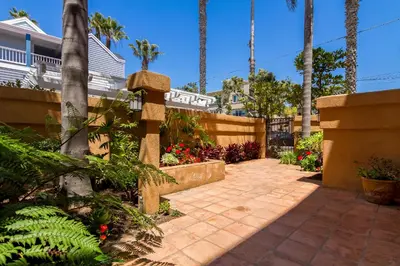 a walkway in a yard with palm trees and flowers at Ocean View Steps to Beach M-C in Oceanside