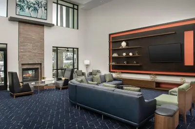 a living room with a couch and a flat screen tv at Courtyard by Marriott San Diego Carlsbad in Carlsbad