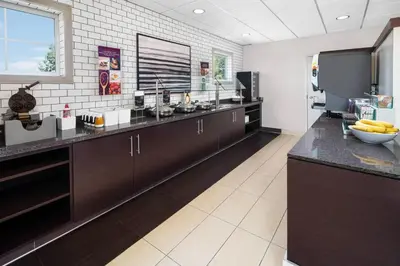 a large kitchen with brown cabinets and a refrigerator at Residence Inn San Diego Rancho Bernardo Scripps Poway in Sabre Springs