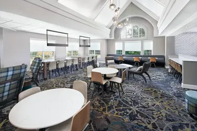 a dining room with tables and chairs and windows at Residence Inn San Diego Rancho Bernardo Scripps Poway in Sabre Springs