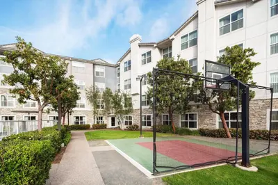 an apartment complex with a basketball hoop in a courtyard at Residence Inn San Diego Rancho Bernardo Scripps Poway in Sabre Springs