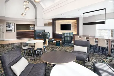 a hotel lobby with tables and chairs and a bar at Residence Inn San Diego Rancho Bernardo Scripps Poway in Sabre Springs