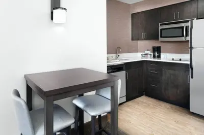 a small kitchen with a table and a refrigerator at Residence Inn San Diego Rancho Bernardo Scripps Poway in Sabre Springs