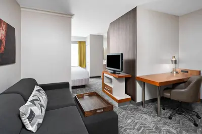 a hotel room with a couch and a desk and a tv at SpringHill Suites San Diego Rancho Bernardo/Scripps Poway in Poway