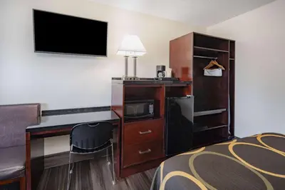 a hotel room with a bed and a desk with a television at Super 8 by Wyndham San Diego Hotel Circle in San Diego