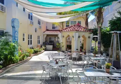 a patio with tables and chairs in front of a building at El Primero Boutique Hotel in Chula Vista