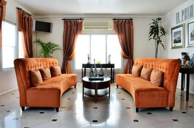 two orange chairs and a table in a living room at El Primero Boutique Hotel in Chula Vista