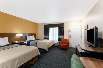 a hotel room with two beds and a television at Days Inn by Wyndham Mission Valley-SDSU in San Diego