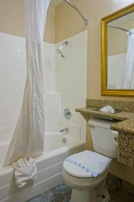 a bathroom with a toilet and a tub and a shower at Days Inn by Wyndham Mission Valley-SDSU in San Diego