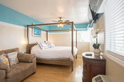 a bedroom with a canopy bed and a couch at The Inn at Sunset Cliffs in San Diego