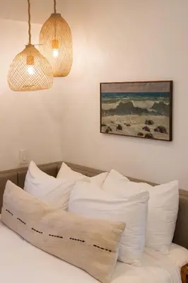 a bedroom with a bed with white pillows and two lights at The Pearl Hotel in San Diego
