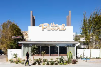 a person walking in front of the pearl hotel at The Pearl Hotel in San Diego