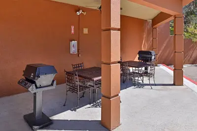 a covered patio with tables and chairs and a grill at Candlewood Suites San Diego by IHG in San Diego