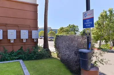 a blue parking sign next to a building with a trash can at Candlewood Suites San Diego by IHG in San Diego