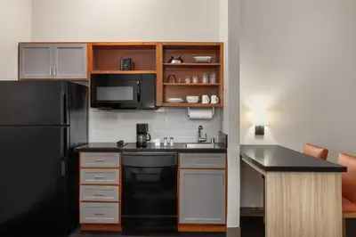 a kitchen with a black refrigerator and a sink at Candlewood Suites San Diego by IHG in San Diego