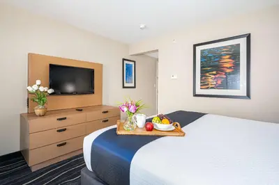 a hotel room with a bed with a tray of fruit on it at Best Western Plus Marina Gateway Hotel in National City