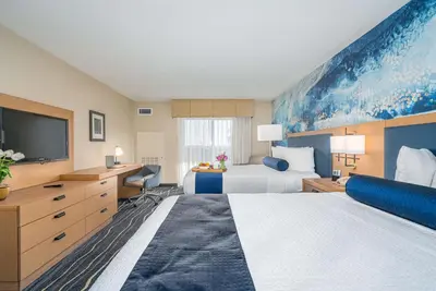 a hotel room with two beds and a flat screen tv at Best Western Plus Marina Gateway Hotel in National City
