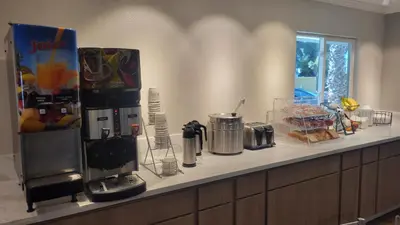a kitchen counter with a coffee maker and some food at SureStay Hotel by Best Western Chula Vista San Diego Bay in Chula Vista
