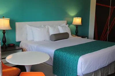a hotel room with a large bed and a table and chairs at Howard Johnson by Wyndham San Diego Hotel Circle in San Diego