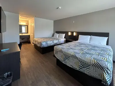 a hotel room with two beds and a television at Motel 6 Lake Elsinore, CA in Lake Elsinore