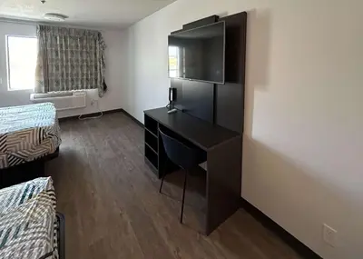 a small room with a desk and a television at Motel 6 Lake Elsinore, CA in Lake Elsinore