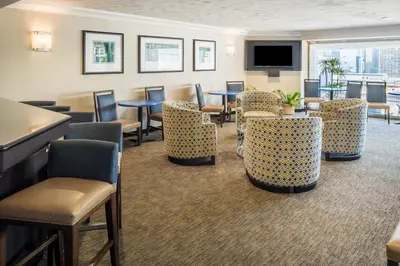 a waiting room with tables and chairs and a tv at Holiday Inn Express - Downtown San Diego by IHG in San Diego