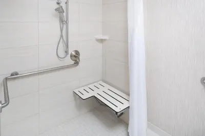 a white shower with a bench in a bathroom at Holiday Inn Express - Downtown San Diego by IHG in San Diego