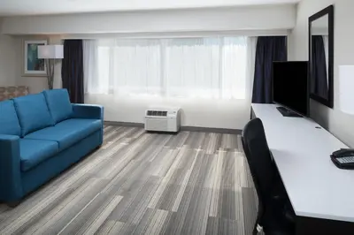 a living room with a blue couch and a television at Holiday Inn Express - Downtown San Diego by IHG in San Diego