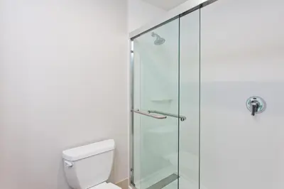 a bathroom with a toilet and a glass shower at Holiday Inn Express Mira Mesa San Diego by IHG in Mira Mesa
