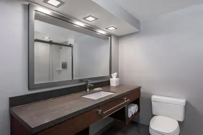 a bathroom with a sink and a toilet and a mirror at Courtyard by Marriott San Diego Miramar in San Diego