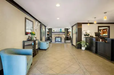 a hallway with blue chairs and a kitchen and a room at Sonesta ES Suites San Diego - Rancho Bernardo in Rancho Bernardo