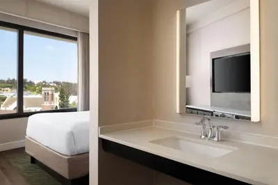 a hotel bathroom with a sink and a tv at The DEXTRO Little Italy, BW Premier Collection in San Diego