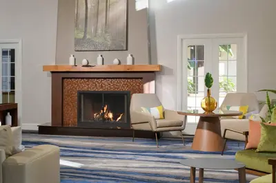 a living room with a fireplace and chairs at Fairfield Inn & Suites San Diego Old Town in San Diego