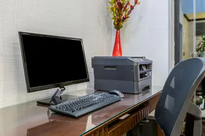 a desk with a computer monitor and a keyboard and printer at Holiday Inn Express San Diego - Sea World Area by IHG in San Diego