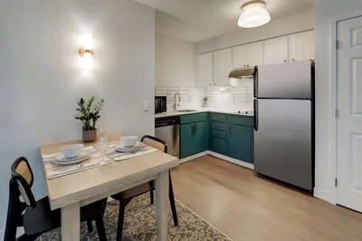 a kitchen with a table and a refrigerator at Sonesta ES Suites San Diego - Sorrento Mesa in Sorrento