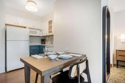 a kitchen with a wooden table and a white refrigerator at Sonesta ES Suites San Diego - Sorrento Mesa in Sorrento