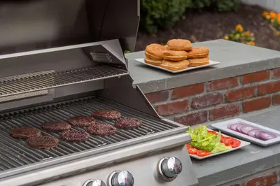 a grill with hamburgers and burgers and a plate of food at Sonesta ES Suites San Diego - Sorrento Mesa in Sorrento