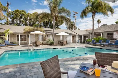 a swimming pool with chairs and a table at Holiday Inn Express and Suites La Jolla - Windansea Beach, and IHG Hotel in San Diego