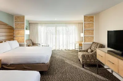 a hotel room with a bed and a flat screen tv at Holiday Inn Express and Suites La Jolla - Windansea Beach, and IHG Hotel in San Diego
