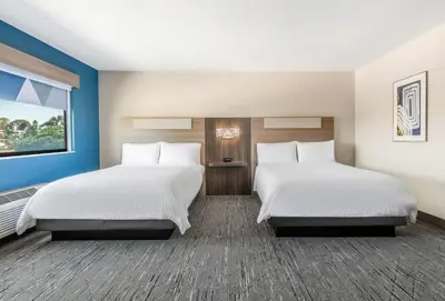 two beds in a room with blue walls at Holiday Inn Express San Diego South - National City by IHG in National City