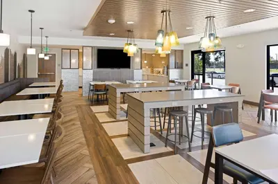 a restaurant with tables and chairs and a bar at Fairfield Inn & Suites by Marriott San Diego Pacific Beach in San Diego