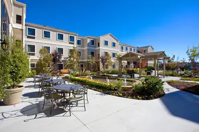 a patio with tables and chairs in front of a building at Staybridge Suites Irvine East/Lake Forest by IHG in Lake Forest