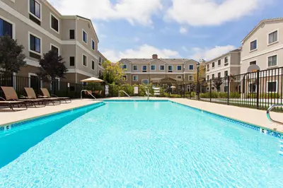 a swimming pool at a apartment complex with a building at Staybridge Suites Irvine East/Lake Forest by IHG in Lake Forest