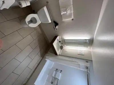 a bathroom with a toilet and a toilet paper dispenser at Holiday Inn Express Hotel & Suites Lake Elsinore by IHG in Lake Elsinore