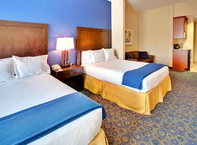 a hotel room with two beds and a chair at Holiday Inn Express Hotel & Suites Lake Elsinore by IHG in Lake Elsinore
