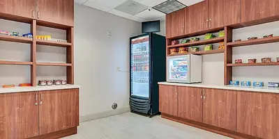 a kitchen with wooden cabinets and a large refrigerator at Holiday Inn Express Hotel & Suites Lake Elsinore by IHG in Lake Elsinore