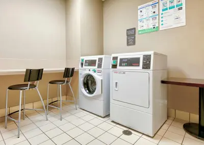 a laundry room with a washer and a washing machine at Hilton Garden Inn Irvine East/Lake Forest in Foothill Ranch